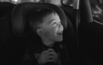 child sitting in car smiling