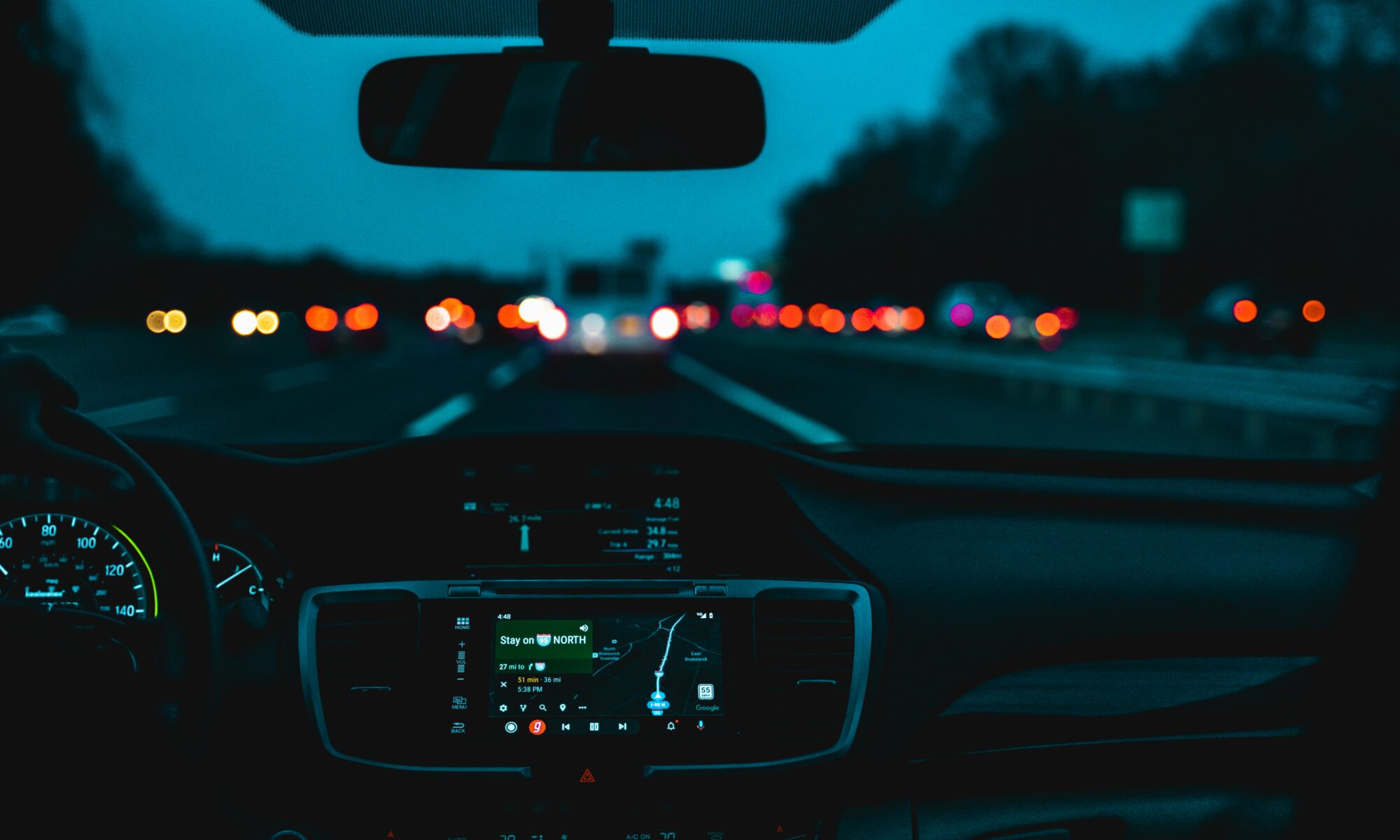 close up of a car's dash and review mirror driving at night