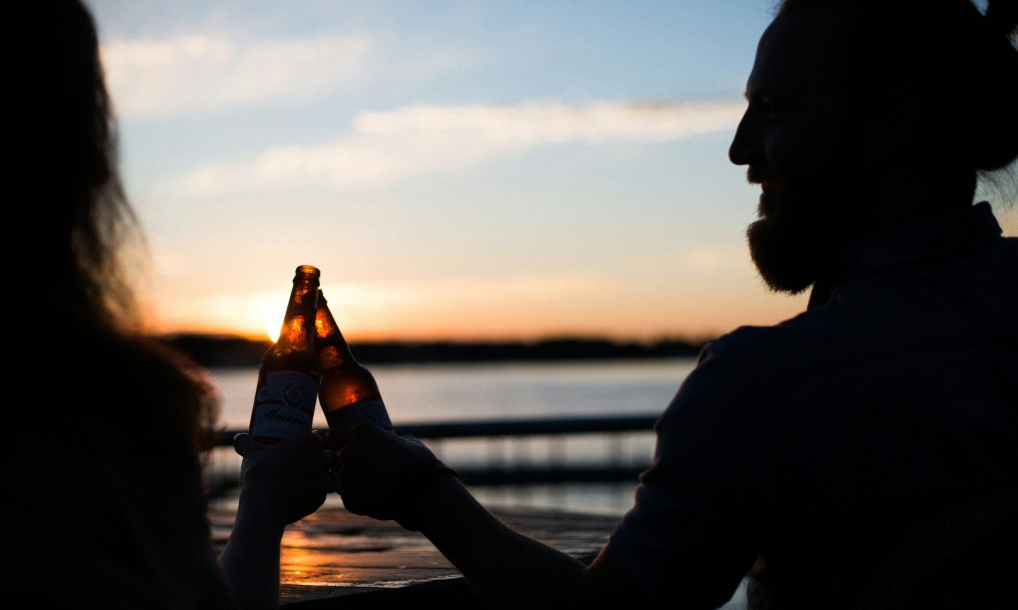 People drinking beer at sunset during summer