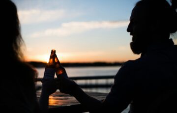People drinking beer at sunset during summer